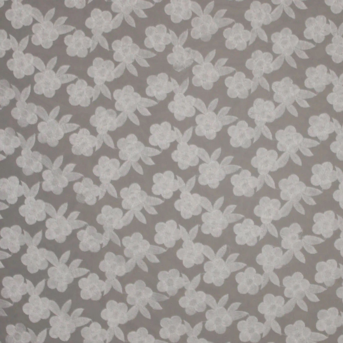 Organza met witte geborduurde bloemen.