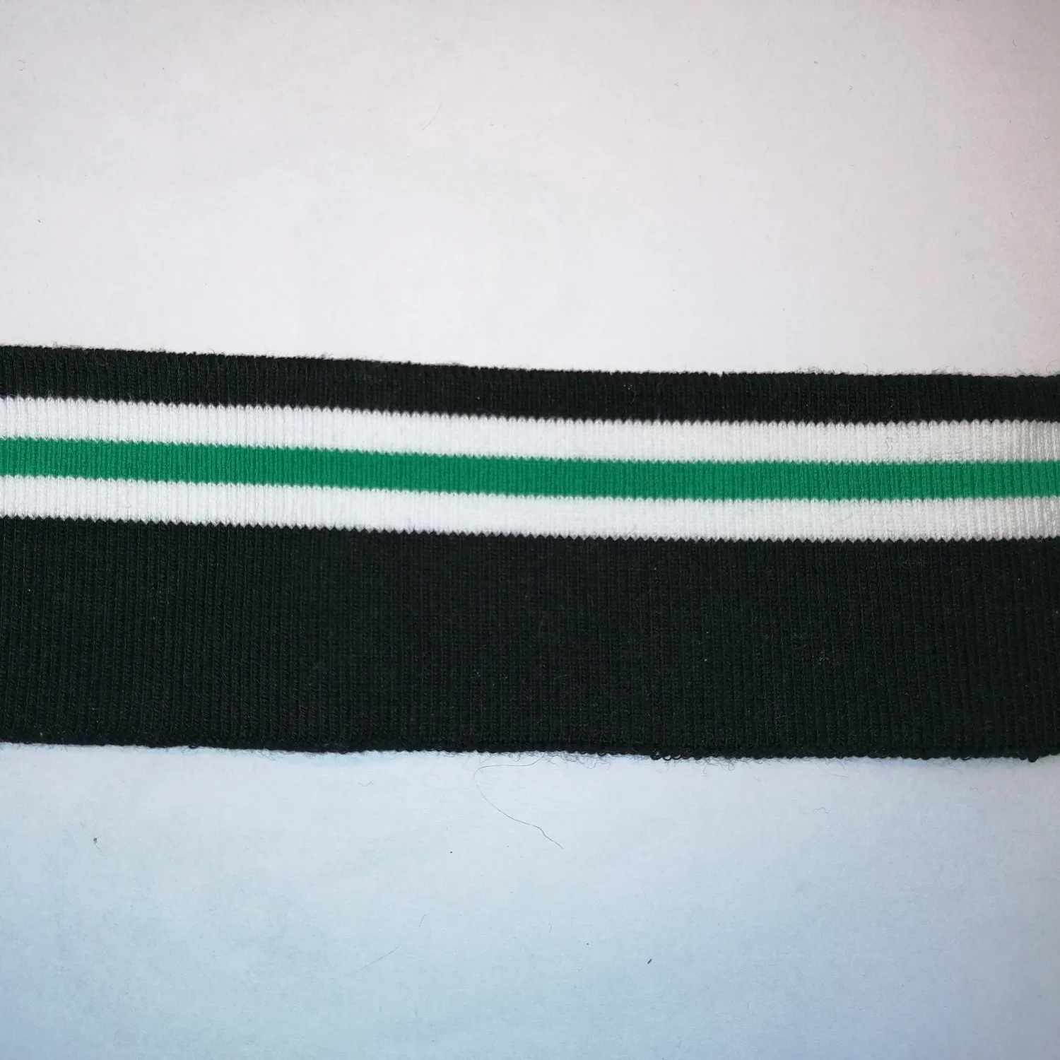 Zwarte cuff (boordstof) met witte en groene strepen