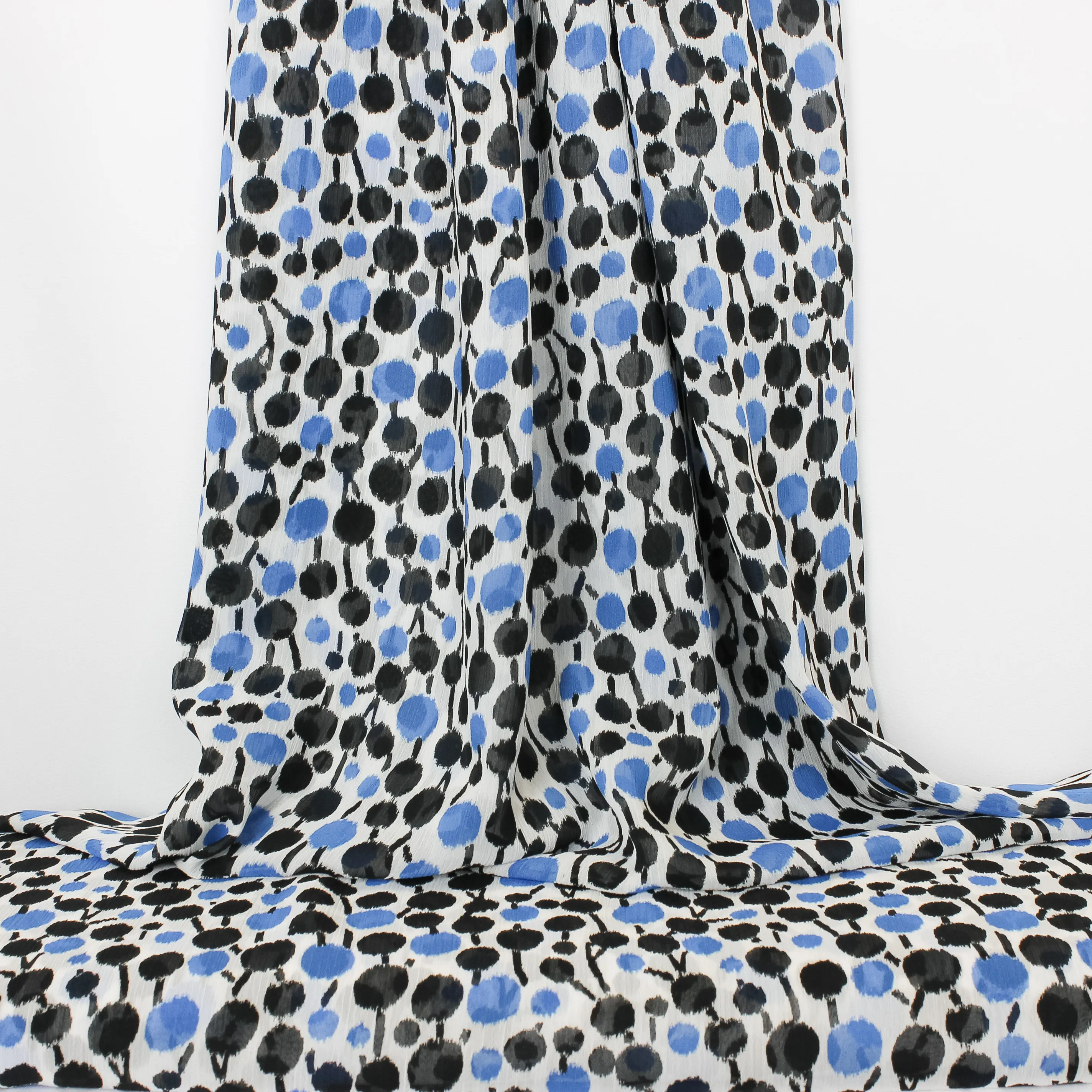 Voile polyester met blauwe en zwarte stippen