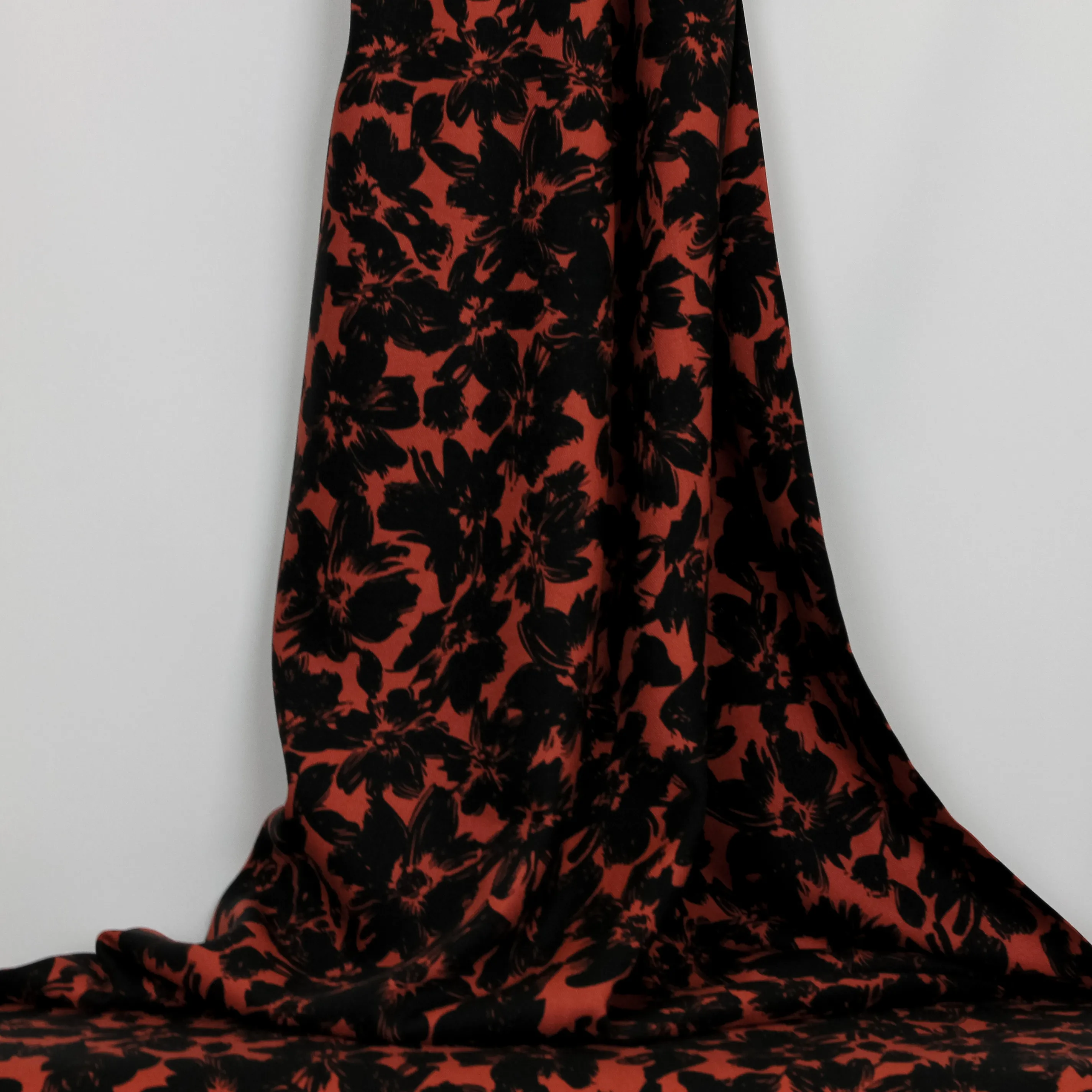Viscose twill oranjerood met zwarte bloemen