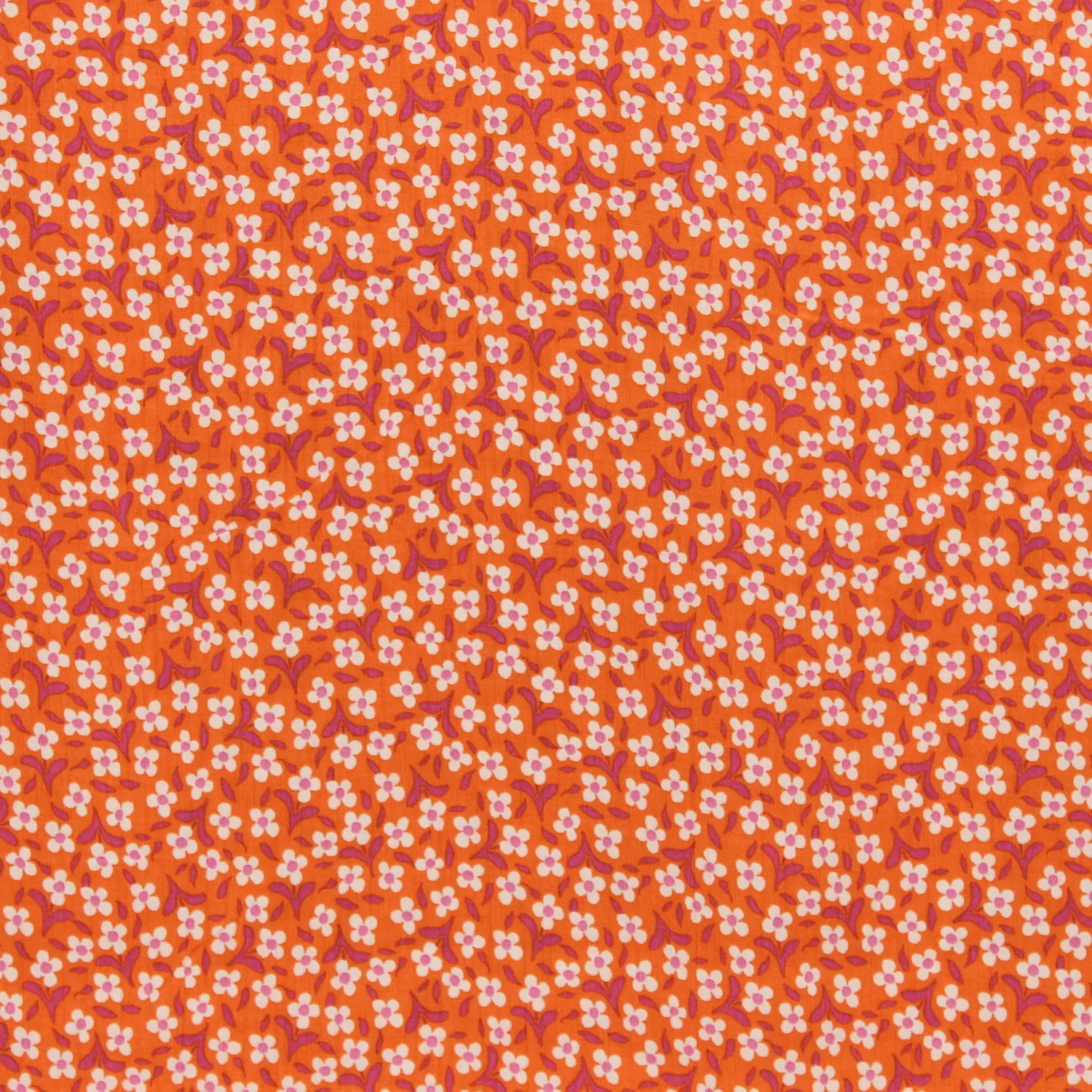 Viscose crêpe oranje met kleine witte bloemetjes - Knipmode